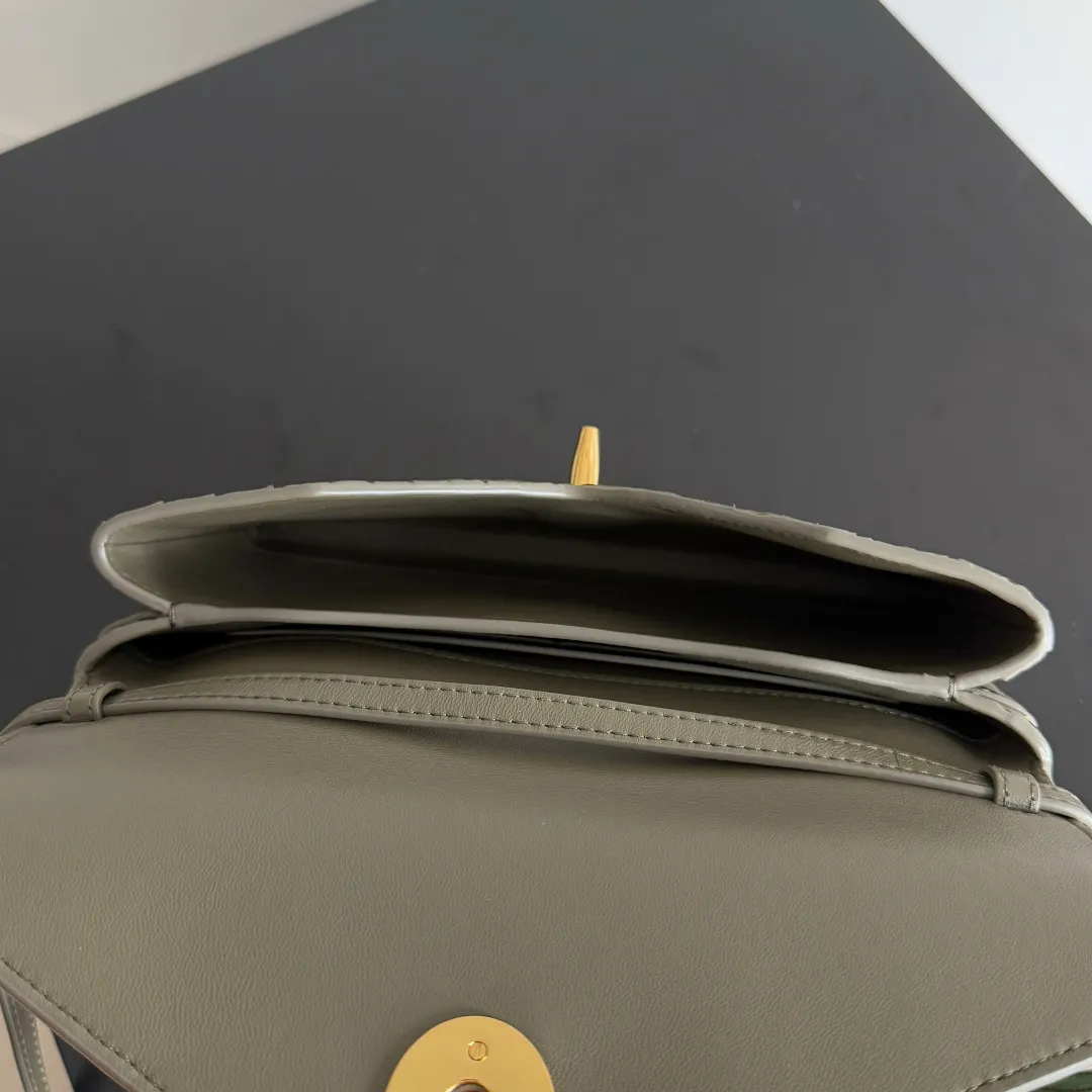 Batch 1660 BOTTEGA VENETA 2025 new product KNOT LOCK crossbody bag subverts the rigid lines of traditional tote bags, using drapey leather to create a three-dimensional silhouette that breathes. It has compartments and multiple card slots inside, making it a versatile commuter bag that can be used in various occasions. The details are full of exquisiteness, the casual retro color tone, and the upper body are full of elegance. Whether you are commuting or going out on the street, you can easily hold it. The two carrying methods of hand-carrying and long shoulder strap are very practical! At the same time, the shoulder strap is detachable, suitable for various dressing styles~ Whether it is a dinner party or daily commuting, it can be easily controlled and becomes your versatile tool❤️ Style number: 817191 Size: 25*16*5.5cm